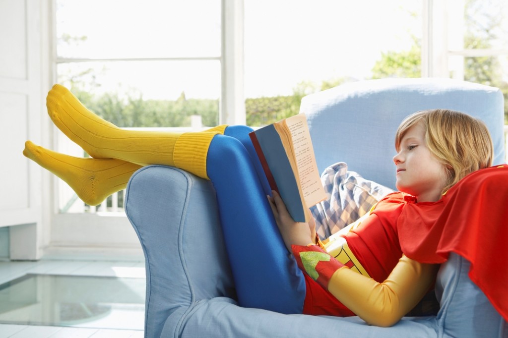 kid in superhero costume on couch