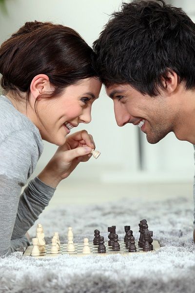 couple playing chess on carpet
