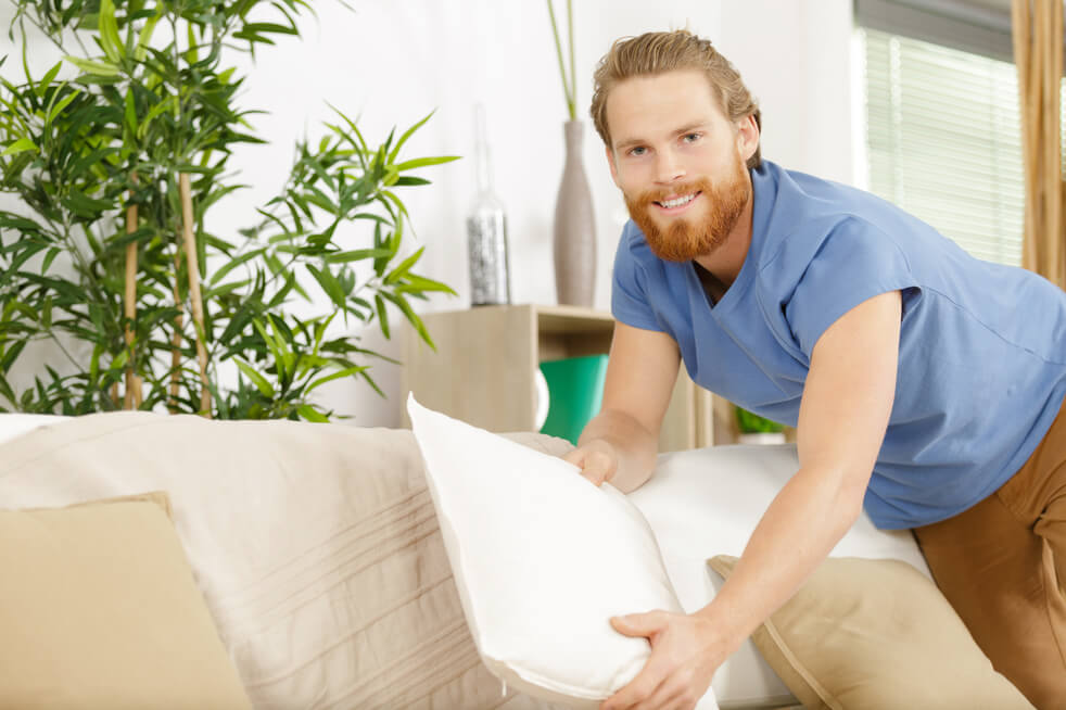 man cleaning up couch